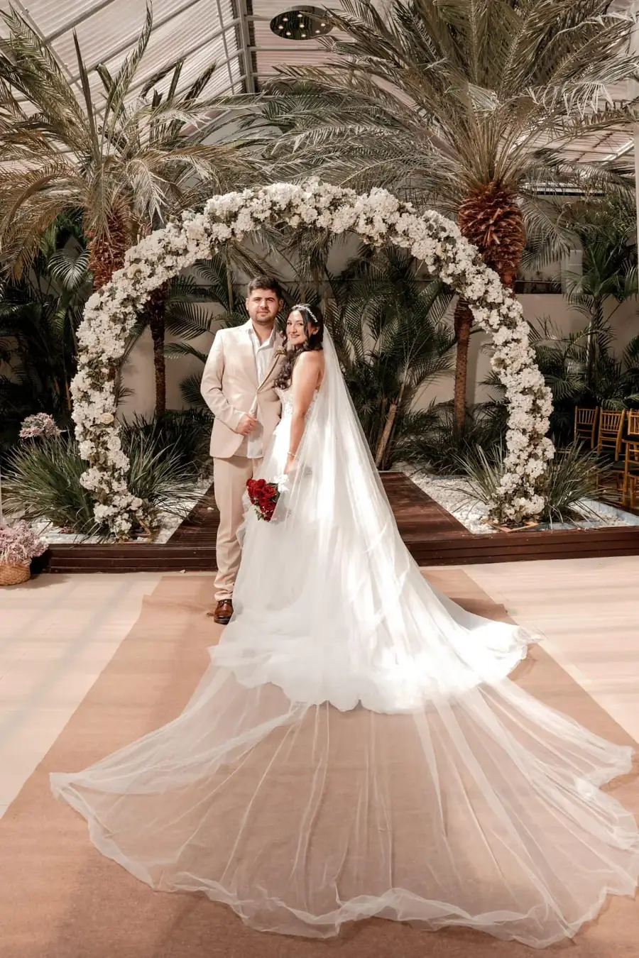 Casal de noivos sob arco floral em cerimônia no Buffet Evento Perfeito